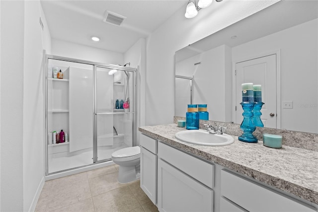 bathroom with vanity, tile patterned floors, toilet, and walk in shower