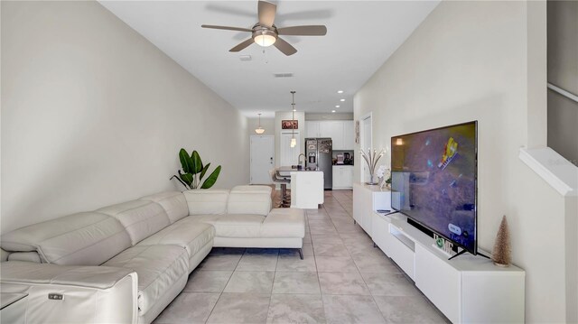 living room featuring light tile patterned floors and ceiling fan