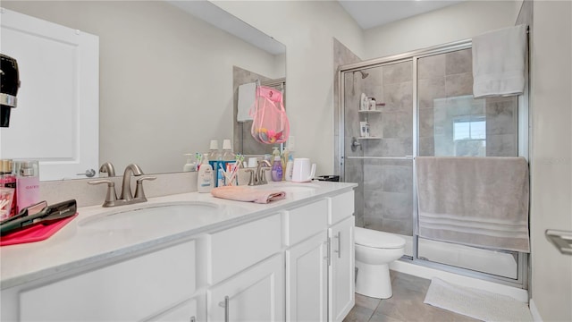 bathroom with vanity, tile patterned flooring, toilet, and walk in shower