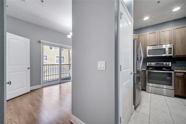 kitchen with a chandelier, stainless steel appliances, and light wood-type flooring