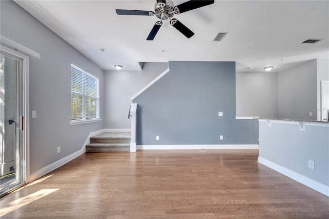 unfurnished living room with ceiling fan and light hardwood / wood-style flooring