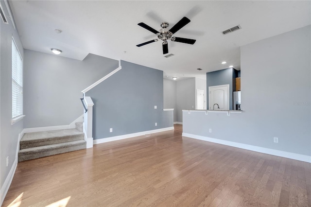 unfurnished living room with light hardwood / wood-style floors and ceiling fan