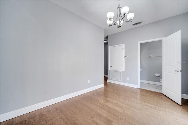 interior space with light hardwood / wood-style flooring, a spacious closet, and a notable chandelier