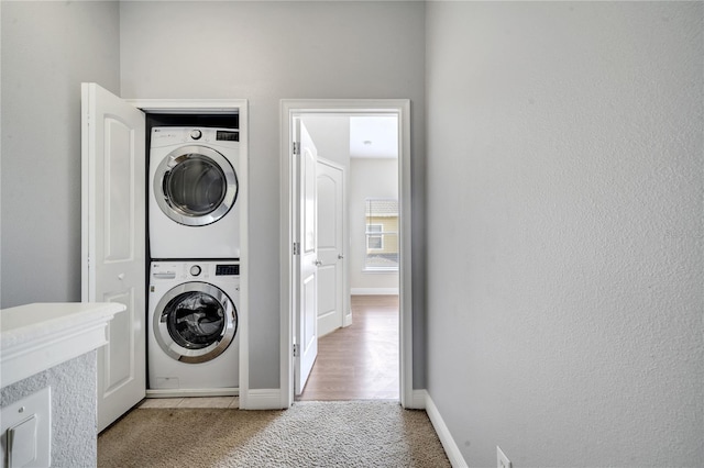 washroom featuring carpet floors and stacked washing maching and dryer