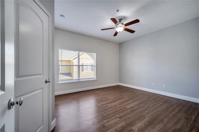 empty room with ceiling fan and dark hardwood / wood-style flooring