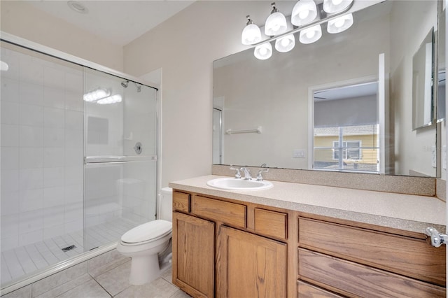 bathroom featuring a shower with door, vanity, toilet, and tile patterned floors