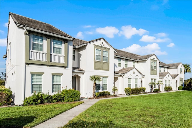 view of front of home featuring a front lawn and a balcony