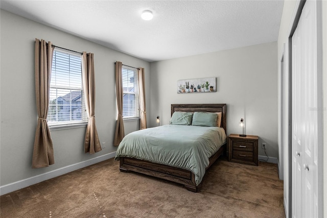 carpeted bedroom featuring baseboards and a textured ceiling