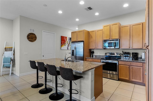 kitchen featuring dark stone countertops, light tile patterned flooring, visible vents, and appliances with stainless steel finishes