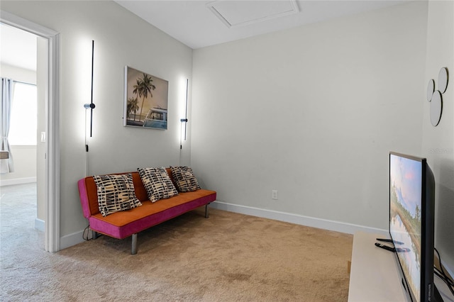 sitting room with baseboards, attic access, and carpet flooring