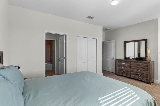 bedroom with visible vents, carpet, a closet, and ensuite bathroom