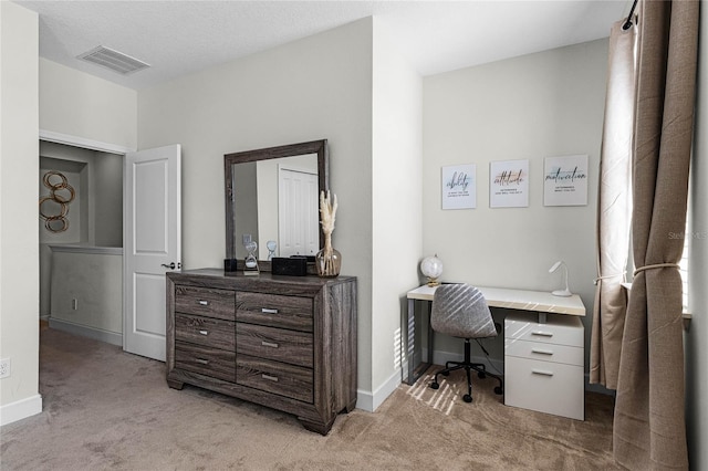 office featuring visible vents, light carpet, and baseboards