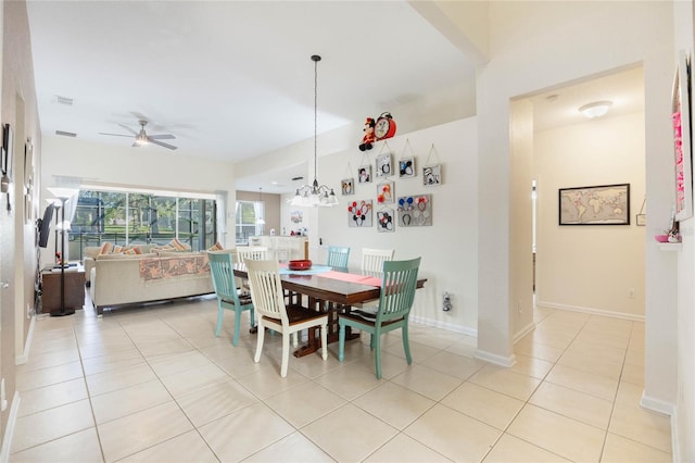 tiled dining area with ceiling fan with notable chandelier