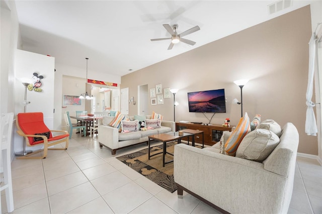 tiled living room featuring ceiling fan with notable chandelier