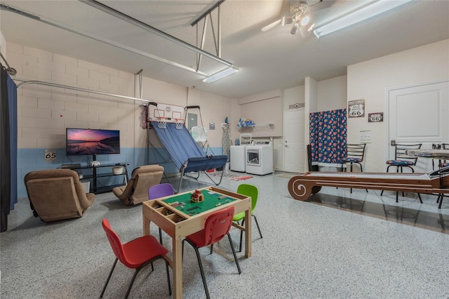 recreation room with washer and dryer and ceiling fan