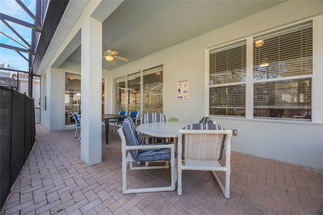 view of patio featuring ceiling fan and a lanai