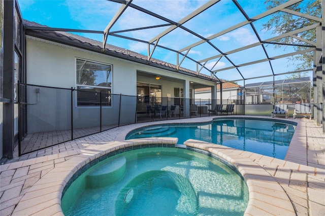 view of swimming pool with an in ground hot tub, a patio area, and a lanai