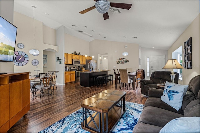 living room featuring dark wood-type flooring, ceiling fan, and high vaulted ceiling