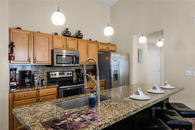 kitchen with a kitchen breakfast bar, stainless steel appliances, backsplash, and pendant lighting