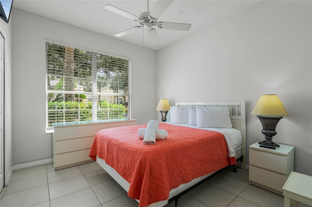 bedroom featuring ceiling fan, a textured ceiling, and light tile patterned flooring