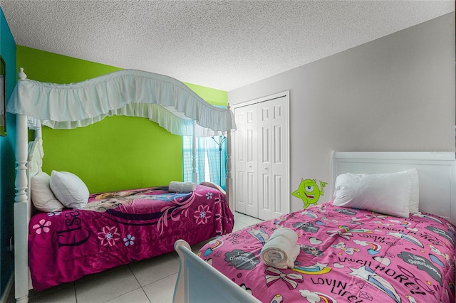 bedroom with a closet, tile patterned floors, and a textured ceiling