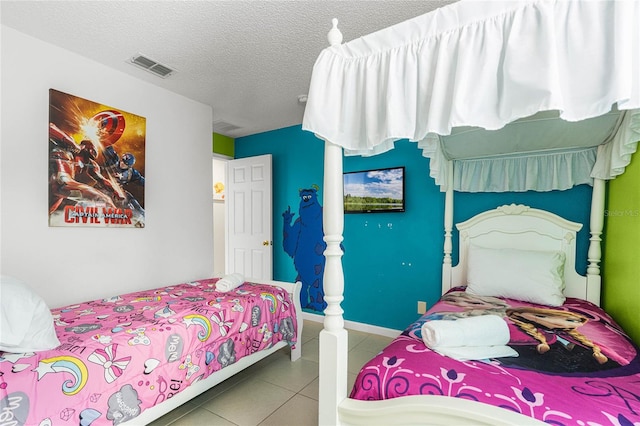 bedroom with a textured ceiling and tile patterned flooring