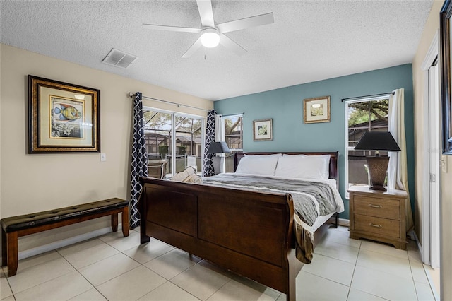 tiled bedroom featuring a textured ceiling and ceiling fan