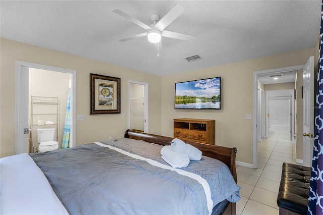 bedroom with ceiling fan, a textured ceiling, a spacious closet, ensuite bathroom, and a closet