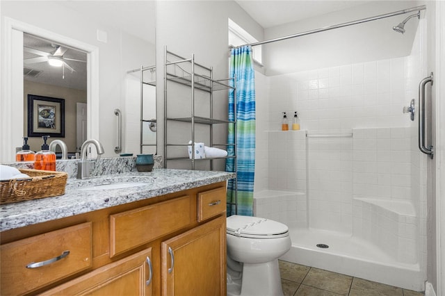 bathroom featuring ceiling fan, toilet, vanity, a shower with curtain, and tile patterned flooring