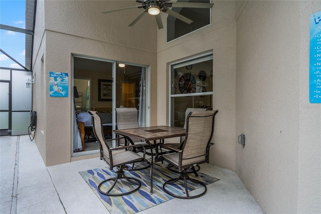 view of patio / terrace with ceiling fan and glass enclosure