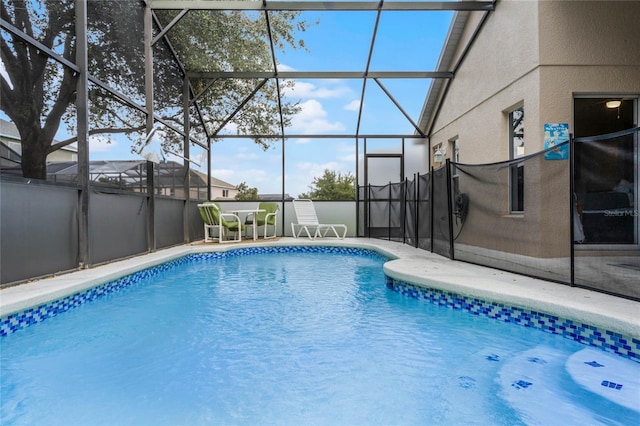 view of swimming pool featuring a patio and a lanai