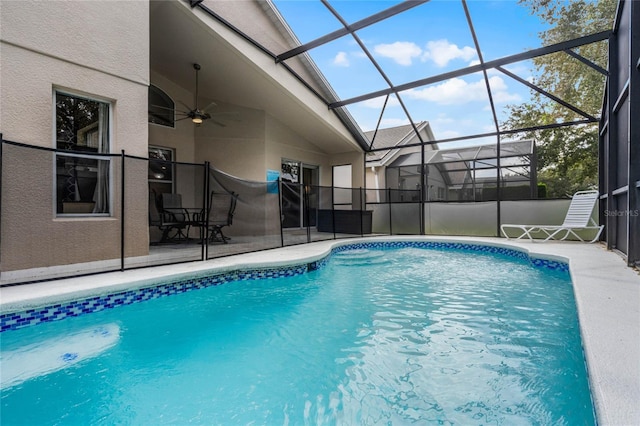 view of swimming pool featuring ceiling fan, glass enclosure, and a patio area