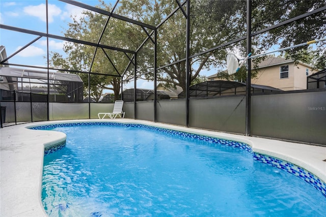 view of swimming pool with a patio area and a lanai