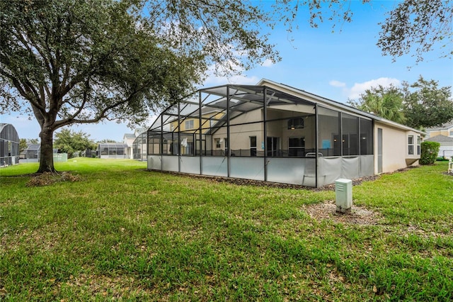 back of house featuring a yard and glass enclosure