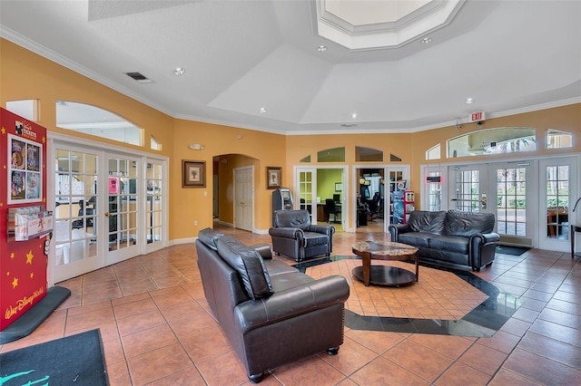 tiled living room featuring french doors, ornamental molding, and a tray ceiling