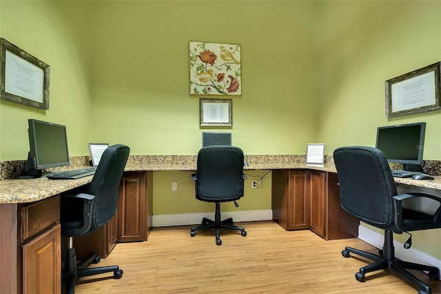 office with light hardwood / wood-style flooring and built in desk