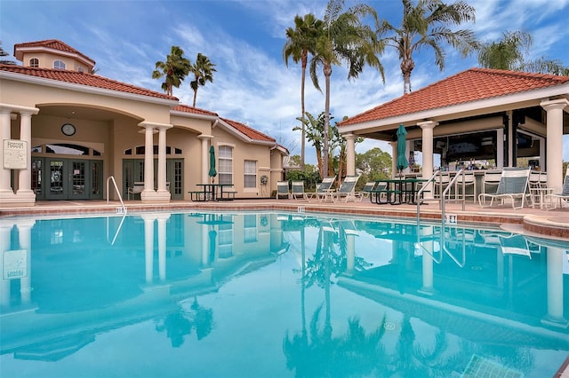 view of pool with a patio area, french doors, and ceiling fan