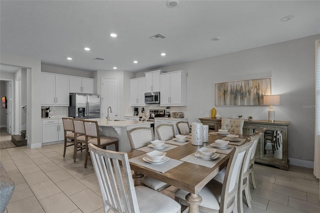 dining area featuring sink and light tile patterned floors