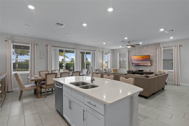 kitchen with sink, a kitchen island with sink, white cabinetry, and ceiling fan