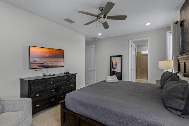 bedroom with light carpet, ceiling fan, and ensuite bath