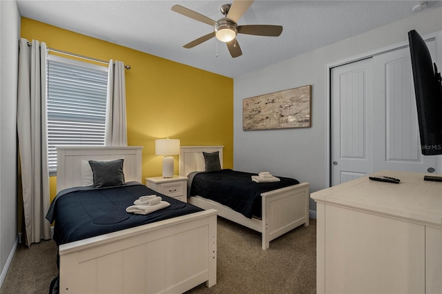 carpeted bedroom featuring a closet, a textured ceiling, and ceiling fan