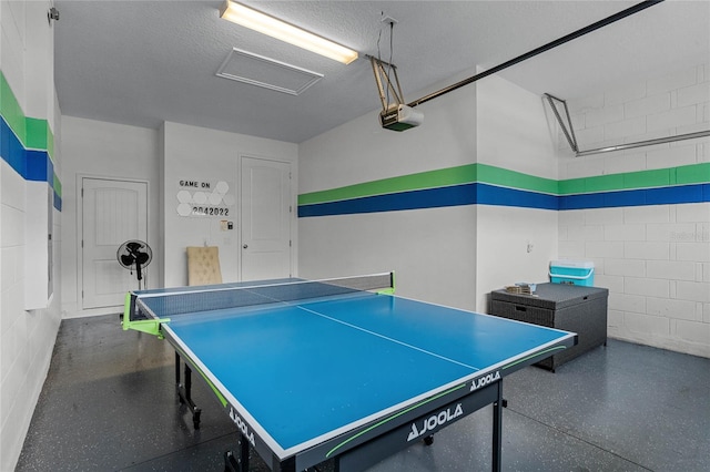 recreation room featuring a textured ceiling