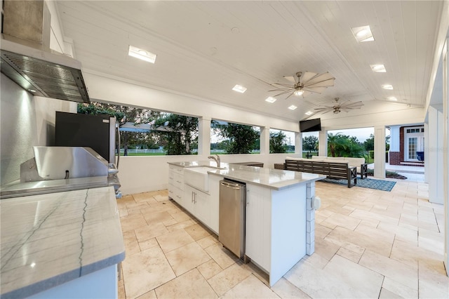 kitchen featuring lofted ceiling, wood ceiling, white cabinets, sink, and an island with sink