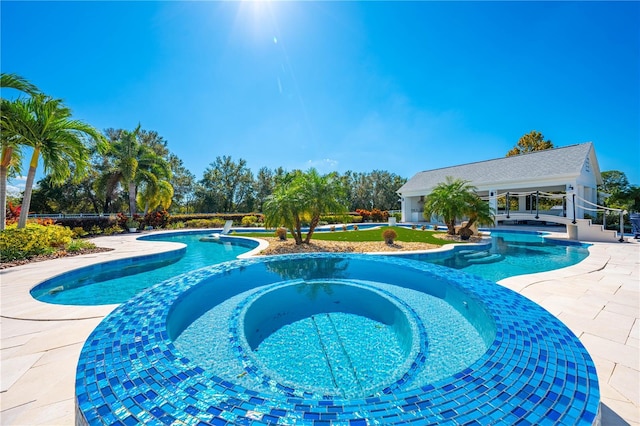 view of pool with a patio and an in ground hot tub