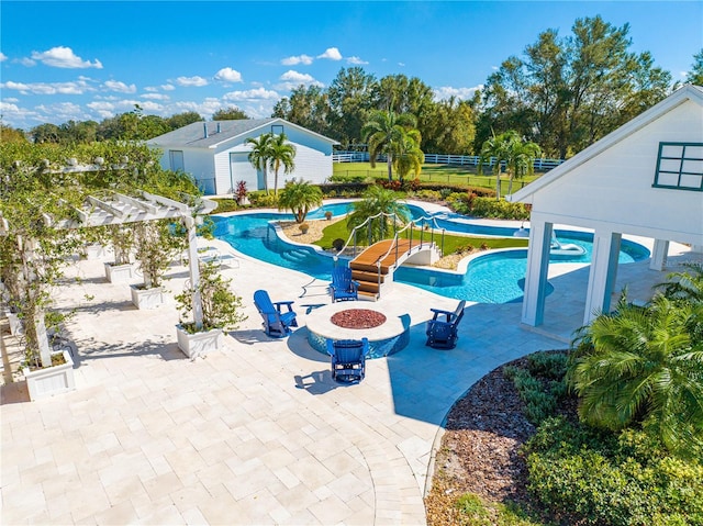 view of swimming pool with a fire pit and a patio