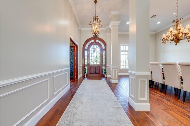 foyer entrance featuring crown molding, dark hardwood / wood-style flooring, and decorative columns