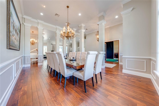 dining space with dark wood-type flooring, crown molding, and an inviting chandelier