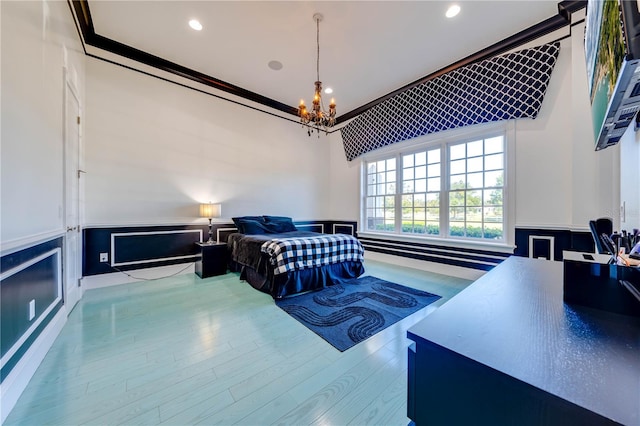 bedroom with an inviting chandelier, light hardwood / wood-style flooring, and crown molding