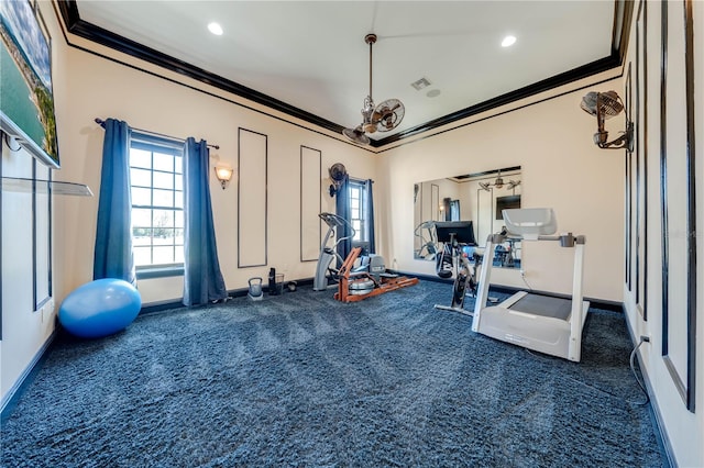 exercise area with ornamental molding and dark carpet