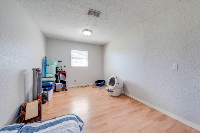 misc room with hardwood / wood-style flooring and a textured ceiling